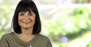 Smiling woman with dark hair and a green top.