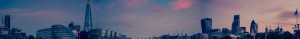 City skyline under a soft, pastel-colored sky at dusk.