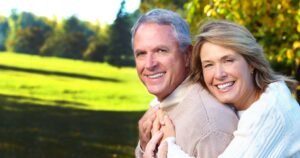 Smiling couple outdoors in sunny park.