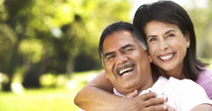 Happy elderly couple embracing outdoors with joyful smiles.