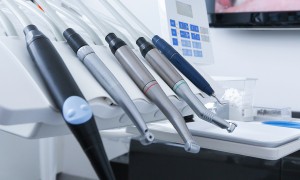 A set of dental handpieces arranged on a tray in a clinic.