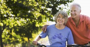 Happy elderly woman enjoying a bike ride outdoors with a companion.