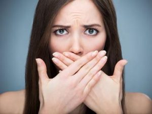 Worried woman covering her mouth with hands.