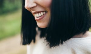Close-up of a smiling woman with straight black hair.