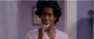 A woman thoughtfully biting her nail, looking concerned.
