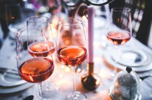 Glasses of rosé wine on a festive table with warm lighting.