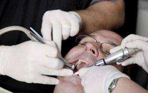 Dentist performing dental procedure on a patient's teeth.