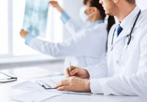 Doctors collaborating and taking notes during a medical discussion.