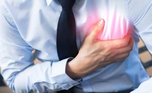 Man clutching chest in apparent heart pain.